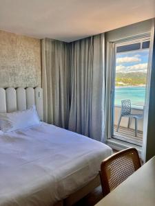 1 dormitorio con cama y vistas al océano en L'Escale Côté Sud en LʼÎle-Rousse