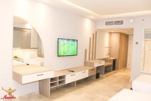 uma casa de banho com dois lavatórios e uma televisão na parede em Aladdin Beach Resort - Families and Couples Only em Hurghada