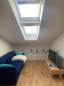 a living room with a blue couch and a skylight at Appartement Havelblick in Berlin