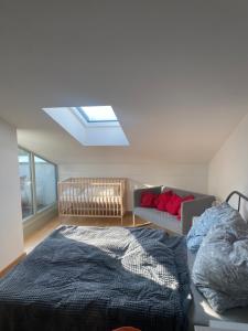 a bedroom with a bed and a couch and a skylight at Appartement Havelblick in Berlin