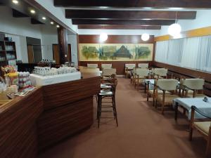 uma sala de jantar com mesas e cadeiras e um bar em Hotel Bečva na Horní Bečvě em Horní Bečva