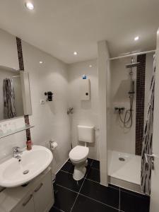 een badkamer met een wit toilet en een wastafel bij HOG Apartment Nürnberg St. Peter in Neurenberg