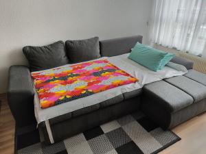 a couch with a colorful blanket on top of it at HOG Apartment Nürnberg St. Peter in Nuremberg
