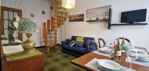 Garden House With Private Parking - Belcantovillas في توري ديل لاغو بوتشيني: غرفة معيشة مع طاولة وأريكة زرقاء