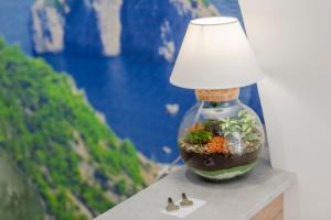 a glass vase with a lamp on a table at Le 5 Perle in Agerola