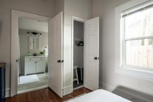 1 dormitorio con puerta blanca y espejo en Bluewater Downtown Cottage, en Wilmington 86 fotos más