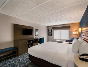 a hotel room with a large bed and a television at Comfort Inn Falls Church - Tysons Corner in Falls Church