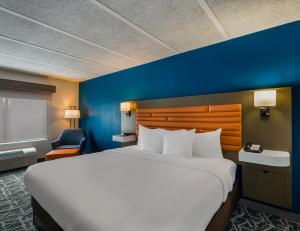 a bedroom with a large bed and a blue wall at Comfort Inn Falls Church - Tysons Corner in Falls Church