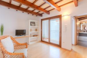 a living room with a chair and a television at Sant Cesc in Ciutadella