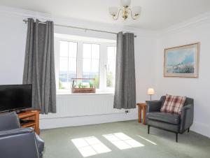 a living room with a chair and a television at Sea View Cottage in Menai Bridge