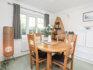 a dining room with a wooden table and chairs at Sea View Cottage in Menai Bridge