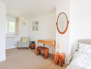 a bedroom with a table and a mirror and a chair at Sea View Cottage in Menai Bridge