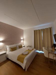 a bedroom with a large white bed and a table at yoyo house Napoli in Naples