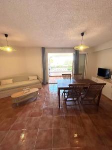 a living room with a table and chairs and a couch at Appartement, 60m2, 6 couchages avec piscines à Marine de Bravone, Linguizetta, résidence Sognu Di mare Corse in Linguizzetta