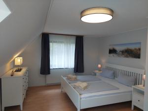 - une chambre avec un lit blanc et une fenêtre dans l'établissement Haus Dietrich Wohnung 1, à Norderney