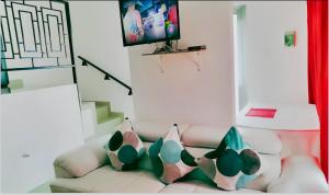 un soggiorno con divano, cuscini e TV di Departamentos Villas Capdeviel a Cancún