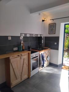 a kitchen with wooden cabinets and a stove top oven at Les Pipistrelles in Bagard
