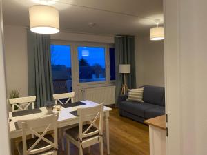 uma sala de estar com uma mesa e cadeiras e um sofá em Tief 10 Wohnung 102 Heimathafen em Wangerland