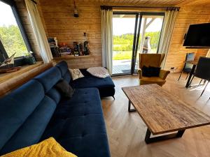 sala de estar con sofá azul y mesa en Mazurski Domek - Wake Up Home Ogonki, en Ogonki