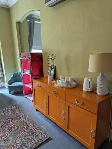Habitación con tocador de madera y lámpara. en Caspian Hotel en Londres