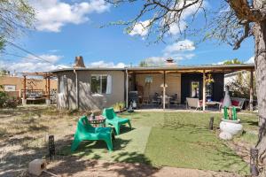 een achtertuin met groene stoelen en een tafel bij Casa de La Rosa in Santa Fe NM in Santa Fe