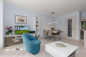 sala de estar con silla azul y mesa en Residenz Blinkfueer Whg_ 6 _Poseid, en Rerik