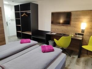 Zimmer mit 2 Betten, einem Schreibtisch und einem Computer in der Unterkunft Hotel Gästehaus Stock Zimmer Bäumle in Friedrichshafen