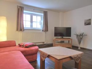 ein Wohnzimmer mit einem Sofa und einem TV in der Unterkunft Ferienwohnung MH3 "Summer Breeze" in Rostock