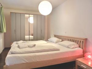 ein Schlafzimmer mit einem großen Bett mit weißer Bettwäsche und Kissen in der Unterkunft Ferienwohnung MH3 "Summer Breeze" in Rostock