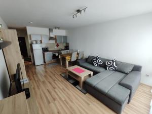 a living room with a couch and a kitchen at HOG Apartment Nürnberg St. Peter in Nuremberg