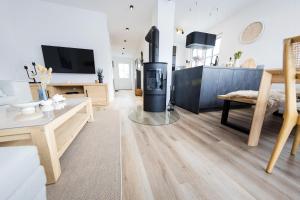 a living room with a fireplace and a tv at Haus Q Superior - Hälfte 2 in Zingst