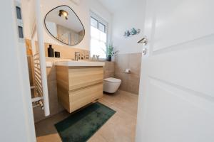 a bathroom with a sink and a mirror at Haus Q Superior - Hälfte 2 in Zingst +16 photos