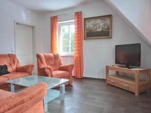 a living room with a couch and a tv at Ferienwohnung MH2 "Sunrise" in Rostock