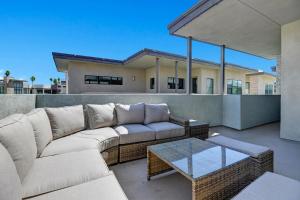 a patio with a couch and a coffee table at The Luxe Vibe in Palm Springs