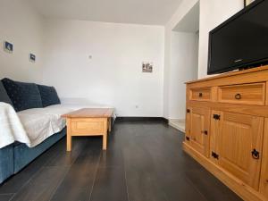 een woonkamer met een bed en een flatscreen-tv bij Charmante Wohnung in Vodice mit Schöner Terrasse - b61717 in Vodice