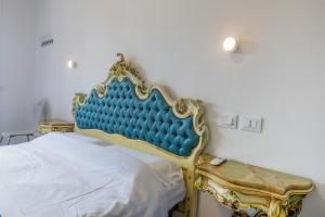 un letto con testiera blu in una stanza di B&B Oasi a Finale Ligure