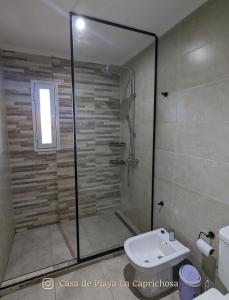 a bathroom with a shower with a toilet and a sink at La Caprichosa Chapadmalal in Chapadmalal