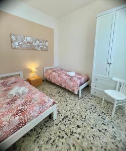 阿尔盖罗Flowered House with garden的一间卧室配有两张床和椅子