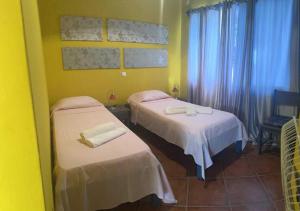 two beds in a room with yellow walls at Villa Baleia Stella Maris Exclusive in Calheta Do Maio +13 photos