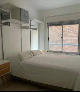 1 dormitorio con cama blanca y ventana en Cañitas 3amb cochera fija techada solo CON RESERVA en Buenos Aires