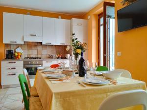 a kitchen with a table with plates and wine glasses at Casa Mattia in Sorico