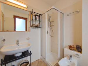 a white bathroom with a sink and a shower at Casa Mattia in Sorico