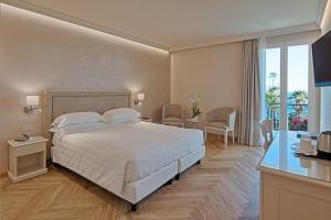 サンレモにあるホテル パラディソのベッドルーム(大型ベッド1台、バルコニー付)