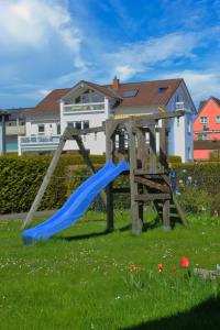 a playground with a blue slide in a yard at Ferienhaus Kitzenwiese in Friedrichshafen