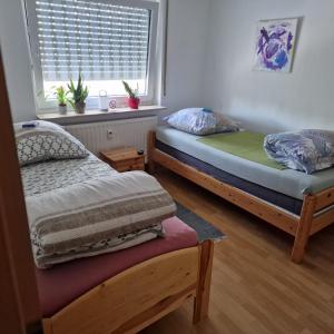 Duas camas num quarto com uma janela em Apartment Arianna Sachsenheim em Sachsenheim