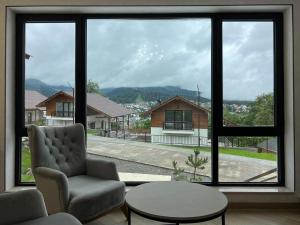 sala de estar con silla y ventana grande en Mount Inn Villa en Bakuriani