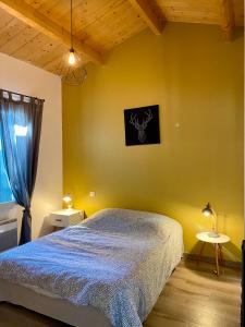 1 dormitorio con cama y pared amarilla en Boinot Lodge en Le Château-dʼOléron