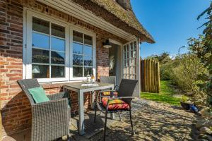 a patio with a table and chairs in front of a house at Altstadttor 5 in Westerland