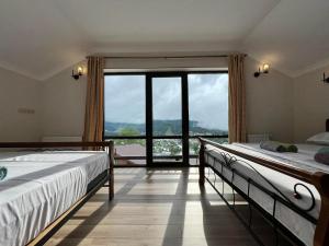 una camera con due letti e una grande finestra di Mount Inn Villa a Bakuriani