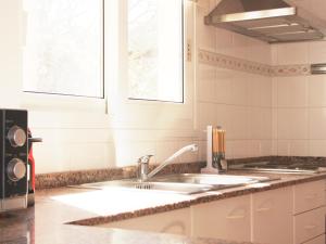 uma cozinha com um lavatório e uma janela em Casa Rainer em Es Figueral Beach